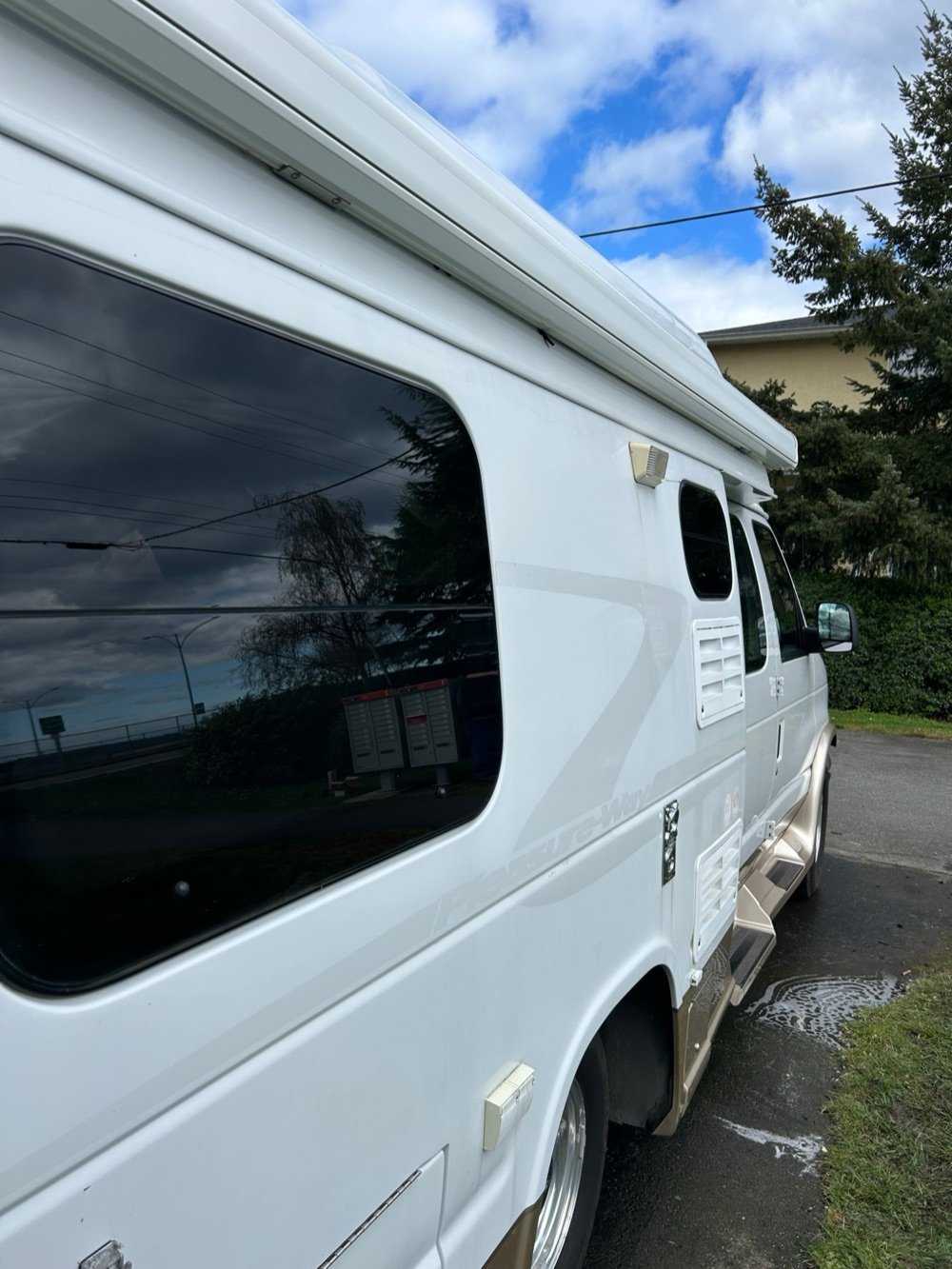 Freshly detailed white Class B RV with clean windows and paint